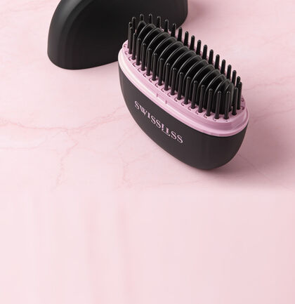 Compacte, sans fil et facile &agrave; transporter, la mini brosse chauffant XOXO Swissliss accompagne toutes vos retouches coiffure !